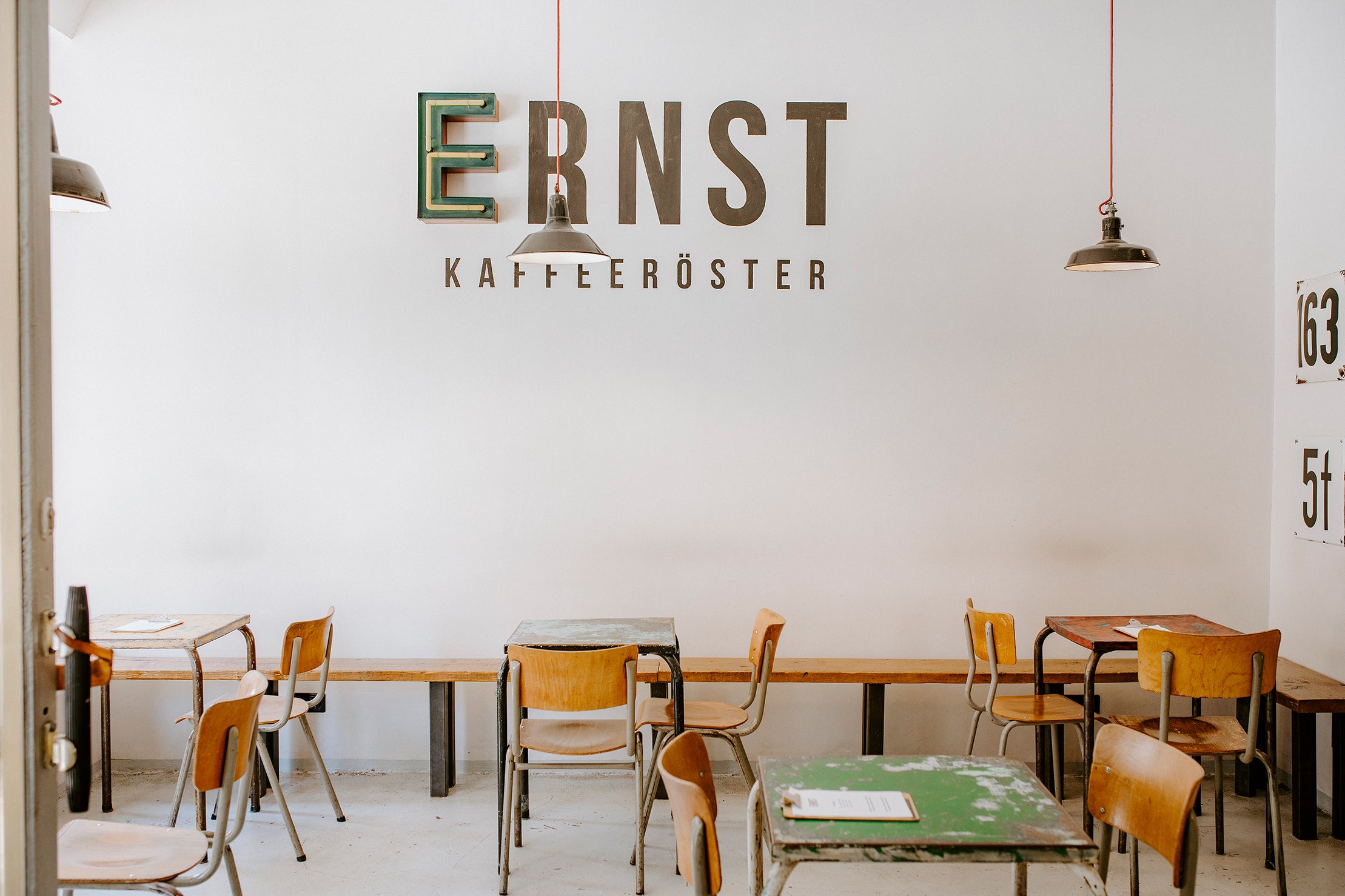 Innenraum der ERNST Kaffeeröster Kaffeebar in Köln Südstadt mit hellem Interieur und Logo