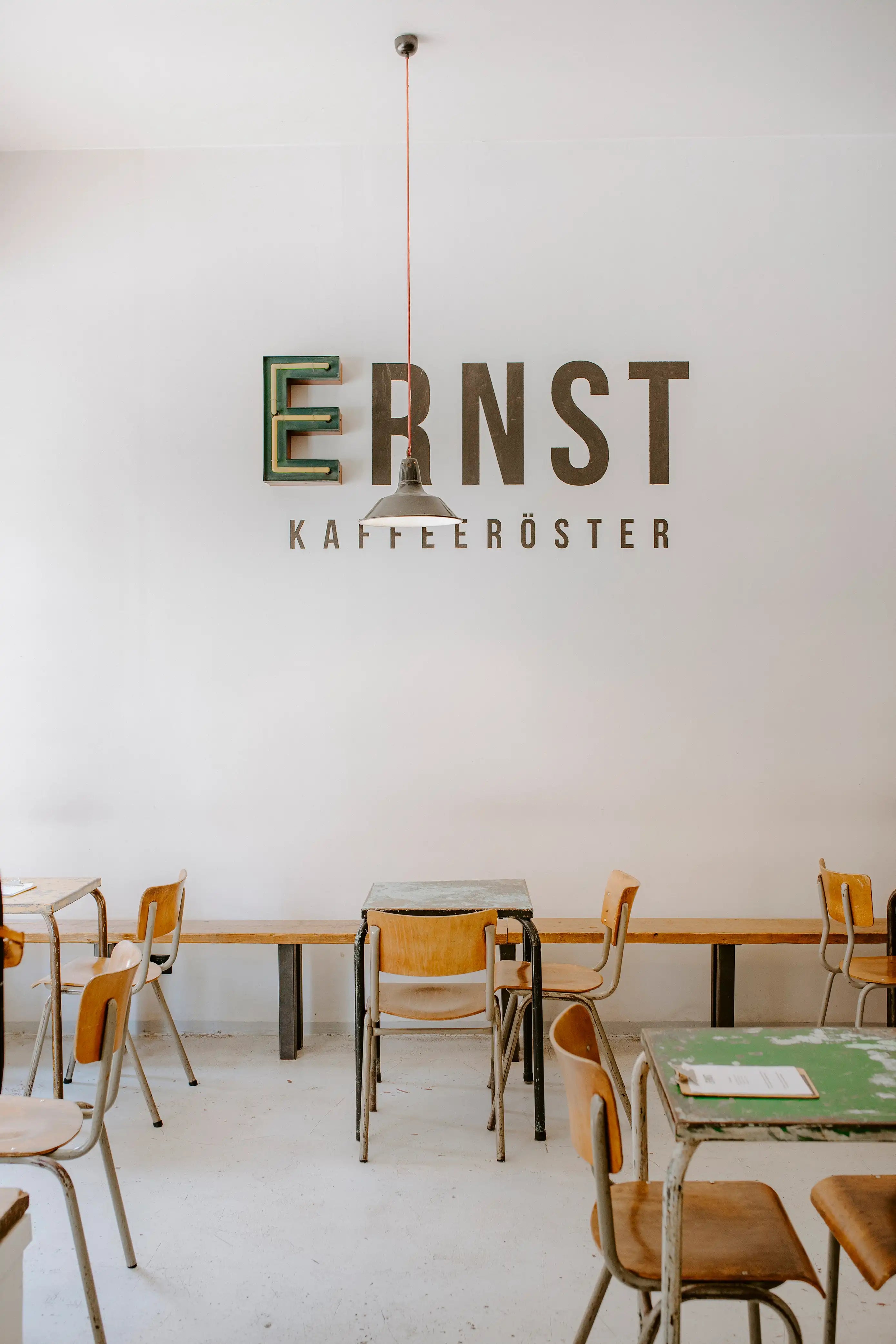 Innenraum der ERNST Kaffeeröster Kaffeebar in Köln Südstadt mit hellem Interieur und Logo