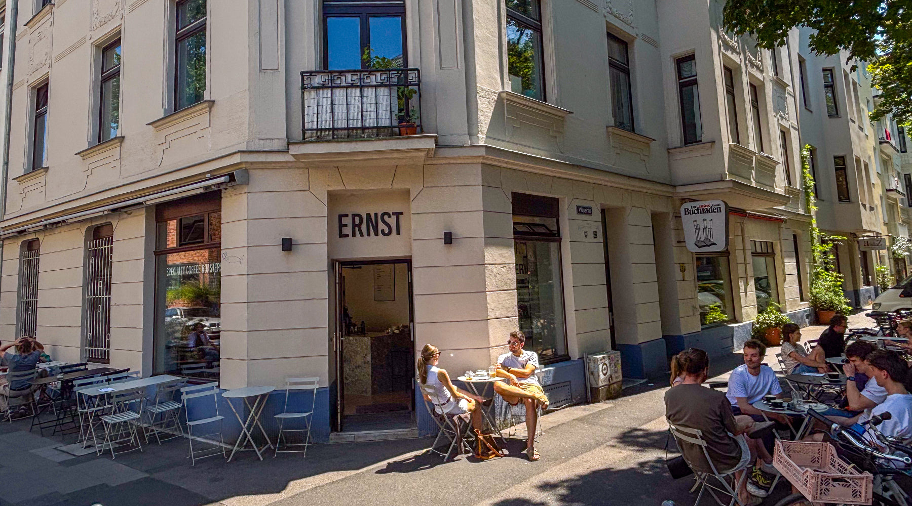 Gäste genießen Kaffee in der Außengastronomie der Ernst Kaffeeröster Kaffeebar in Köln Sülz im Sommer